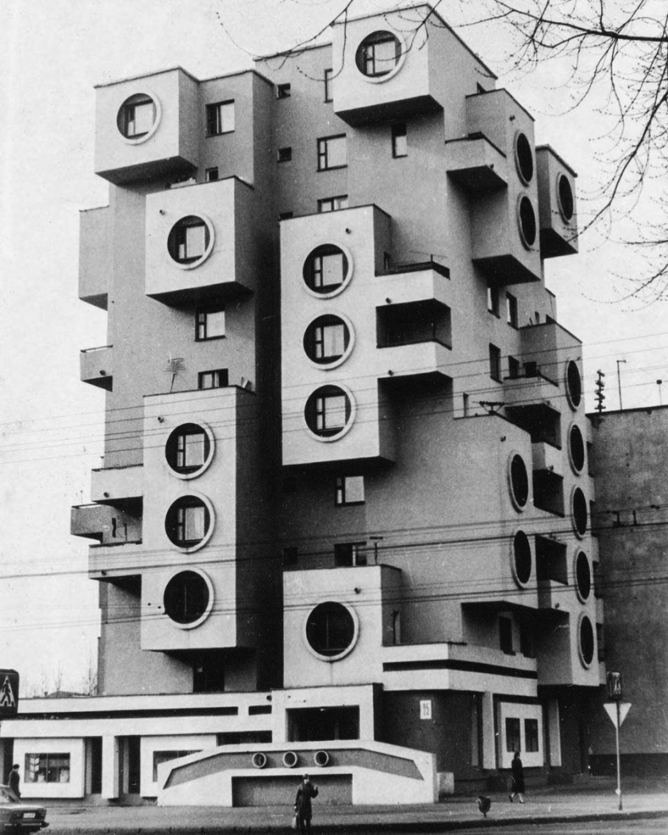 Brutalistická budova s výraznými okrúhlymi oknami a neobvyklými balkónmi v architektonickom štýle futurizmu.