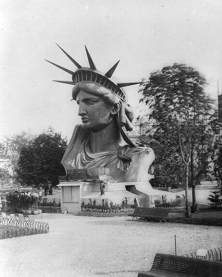 Historická fotografia hlavy Sochy slobody vystavenej v parížskom parku, pred dokončením jej inštalácie v New Yorku.