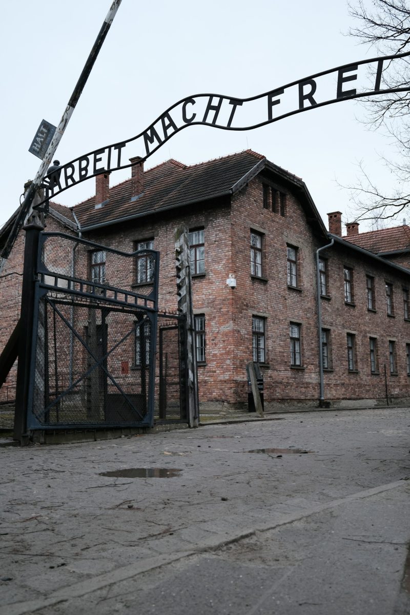 Vstupná brána s nápisom Arbeit macht frei do historického miesta spojeného s pamäťou na smutné udalosti 20. storočia.