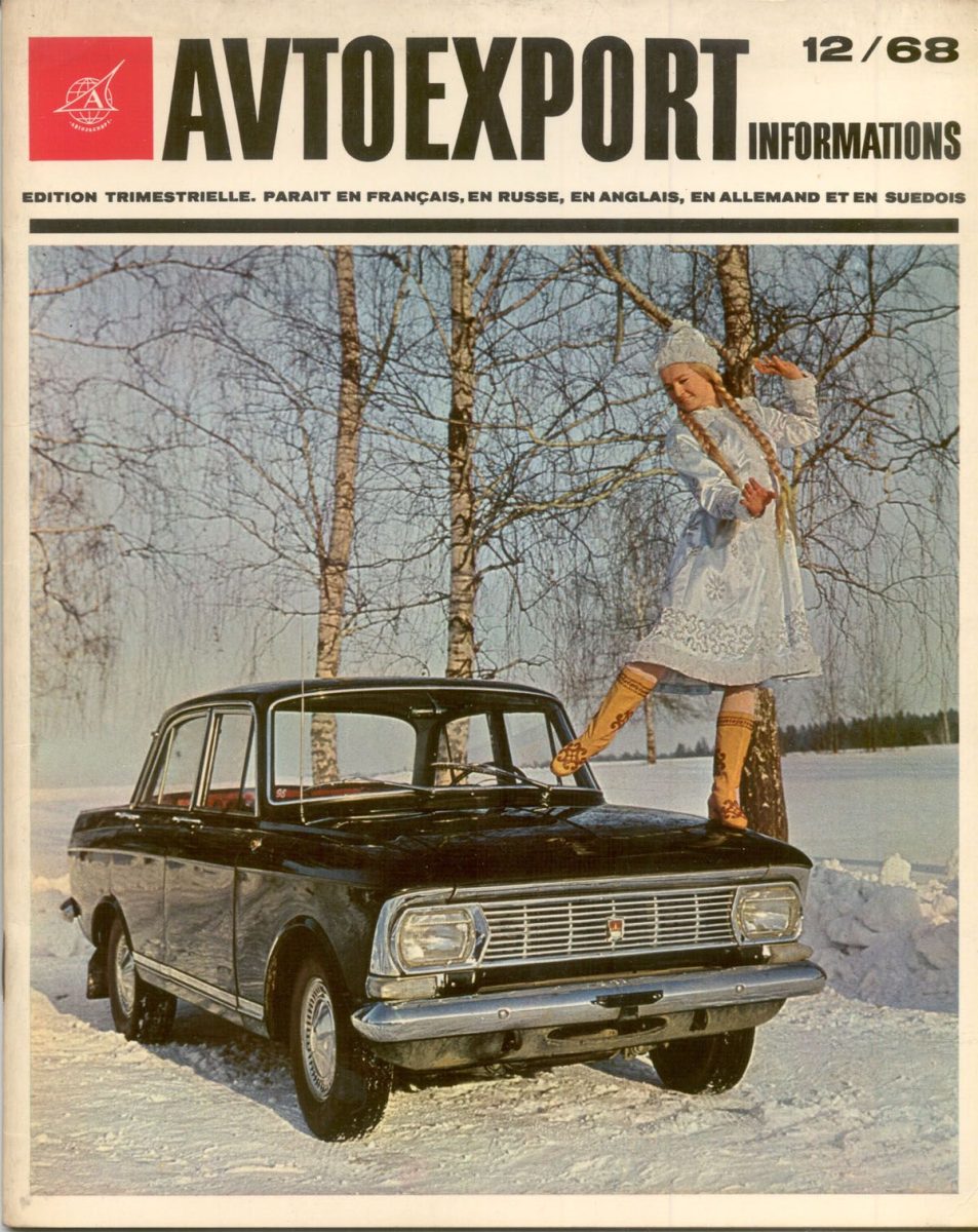 Klasické sovietske auto v zimnej krajine so ženou v tradičnom kroji na kapote.