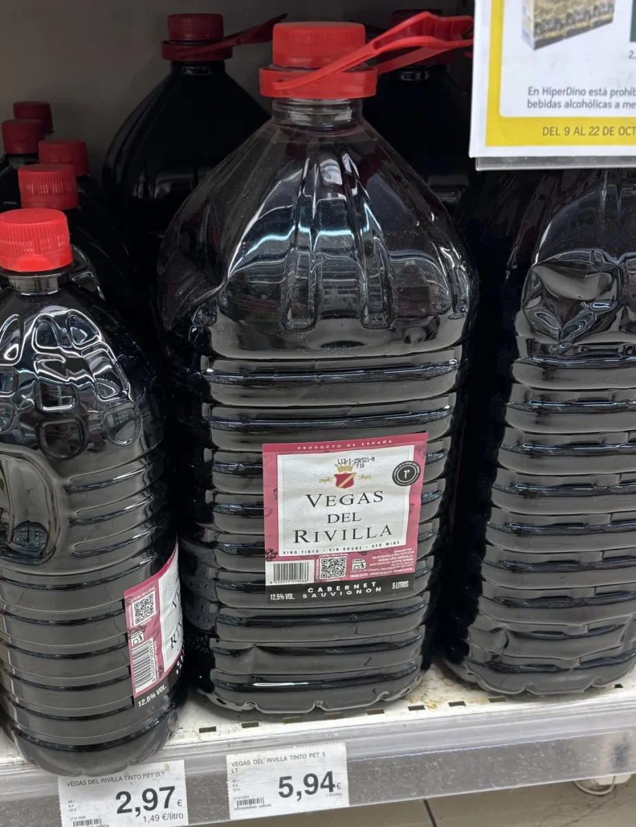 Veľké plastové fľaše červeného vína Vegas del Rivilla s červeným viečkom v regáli supermarketu.