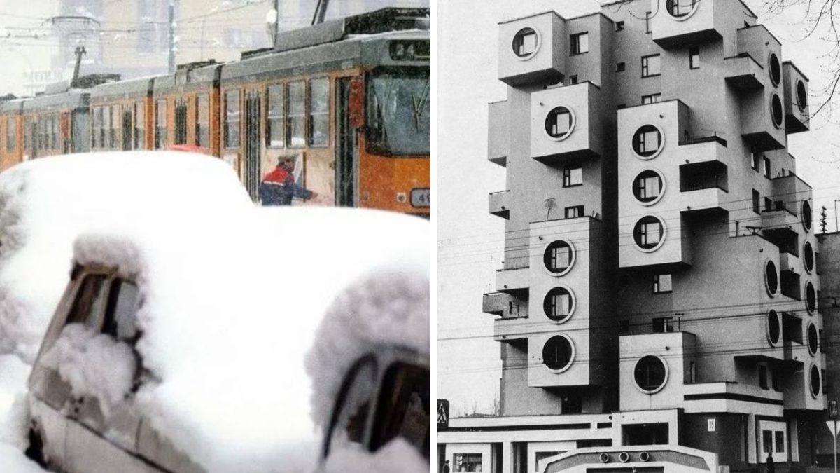 Snehom pokrytá električka a autá vedľa neobvyklého modernistického obytného domu s okrúhlymi oknami.