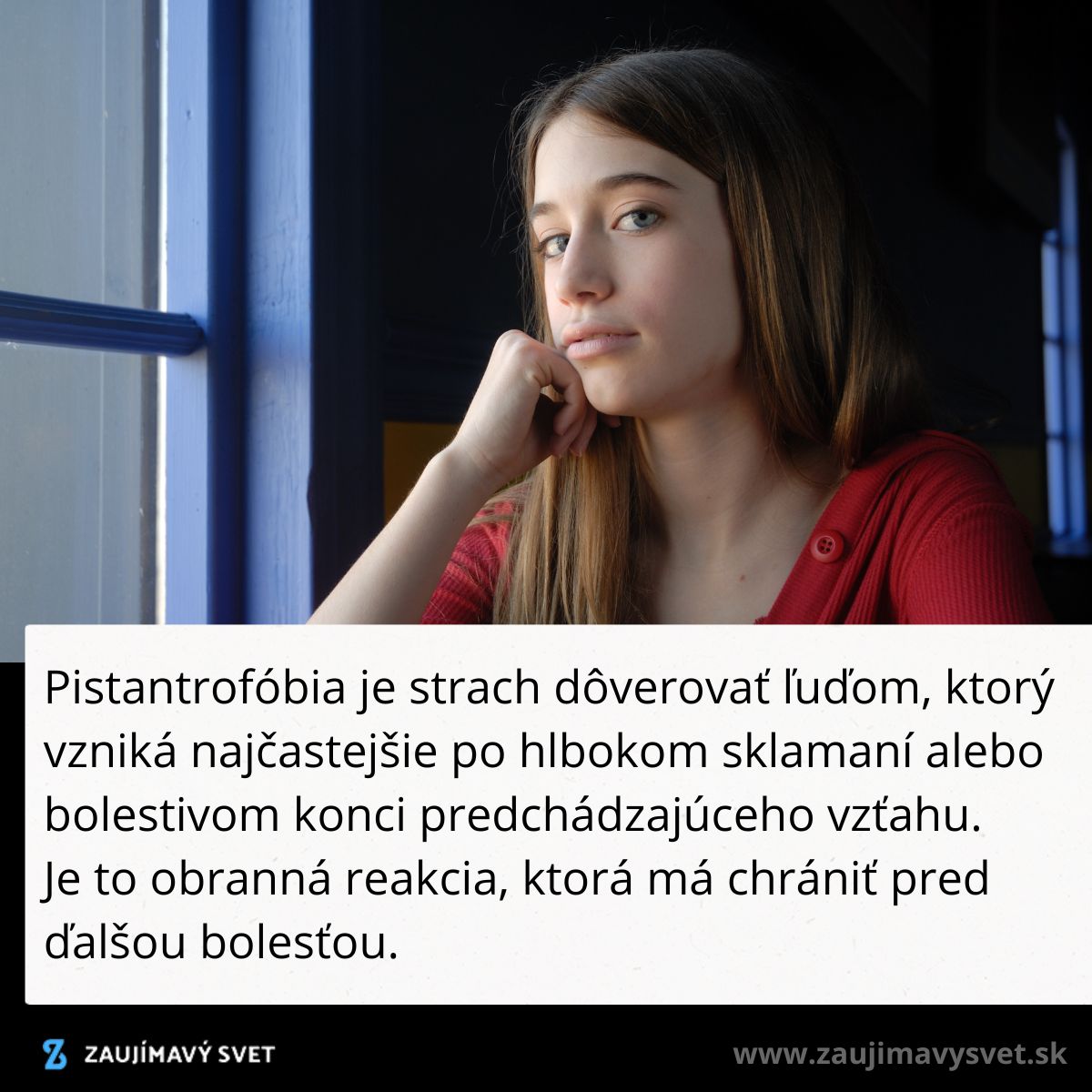 Žena pri okne v červenom svetri premýšľa o pistantrofóbii, strachu z dôvery po zlyhaných vzťahoch.