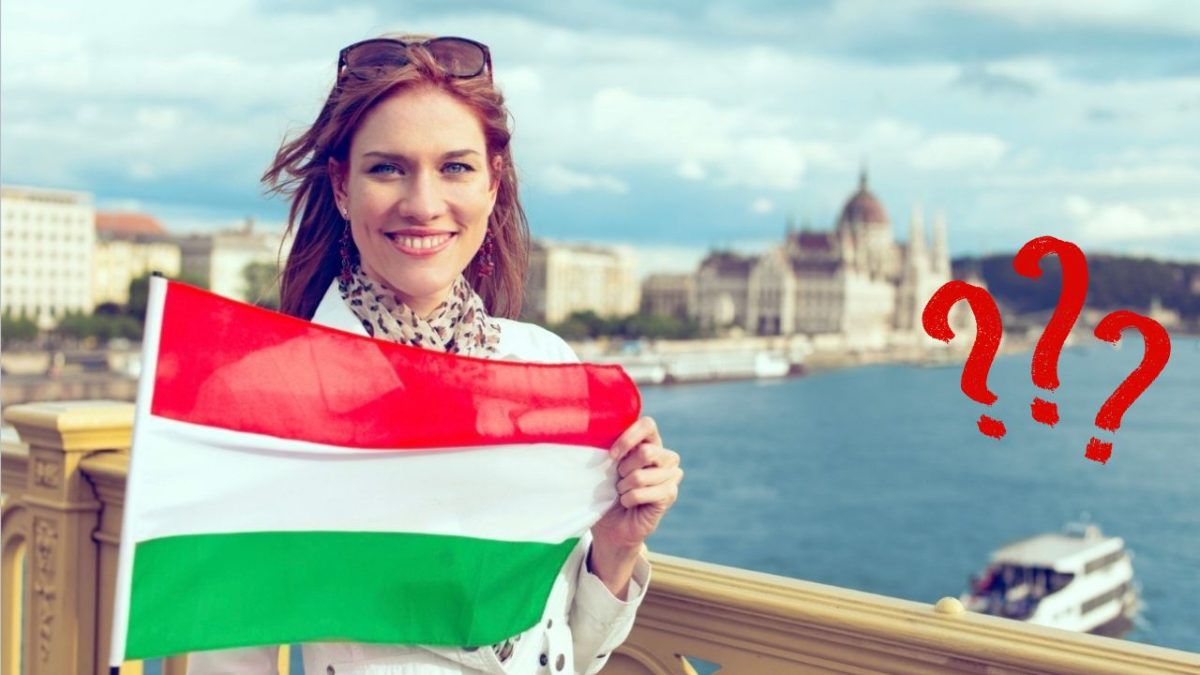Žena držiaca maďarskú vlajku s otáznikmi, Budapešť v pozadí.