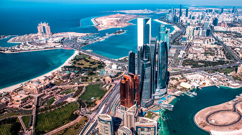 Vzdušný pohľad na moderné mrakodrapy a pobrežie v Abu Dhabi za slnečného počasia.