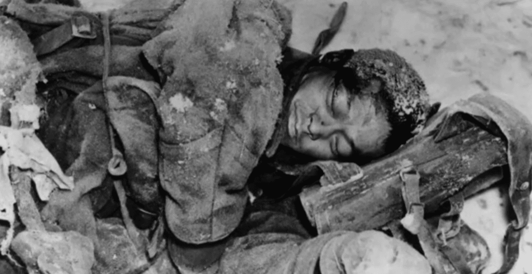 Osoba v zimnom oblečení ležiaca na snehu, predpokladaná historická fotografia v studenom prostredí.