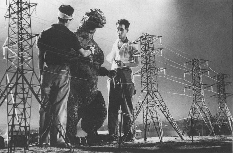 Filmári pripravujú scény s obrovským monštrom medzi elektrickými vežami na scéne.