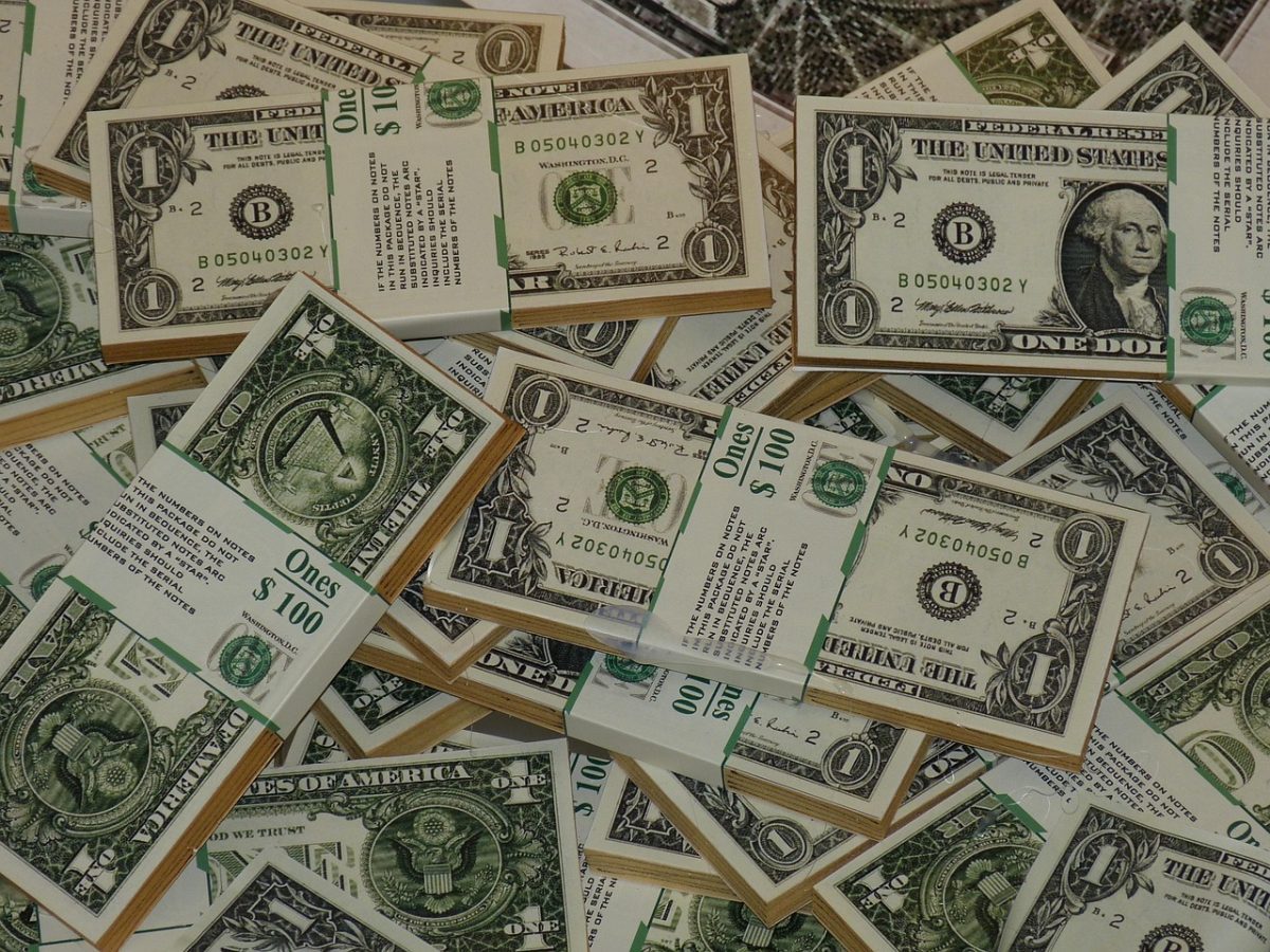 Hromady bankoviek v hodnote jedného dolára, usporiadané do balíčkov označených ako 100 dolárov.