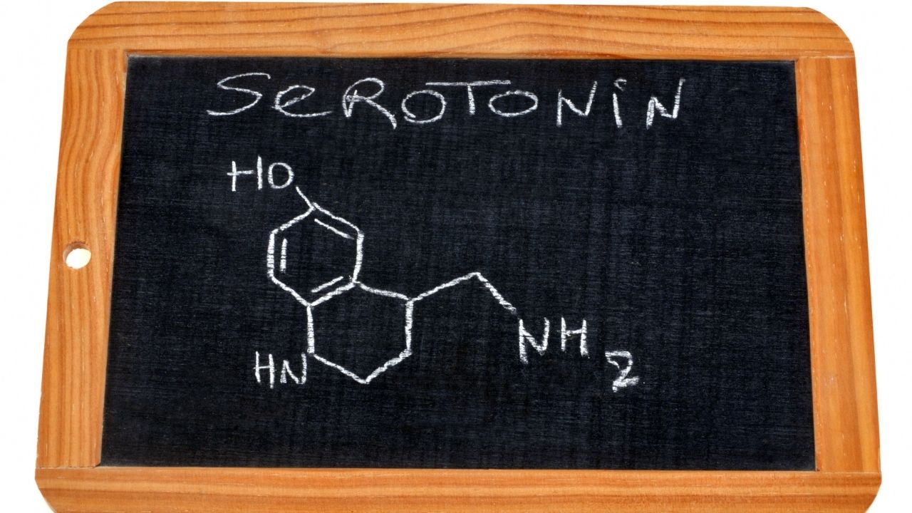 Nápis Serotonín s chemickým vzorcom na tabuľke.