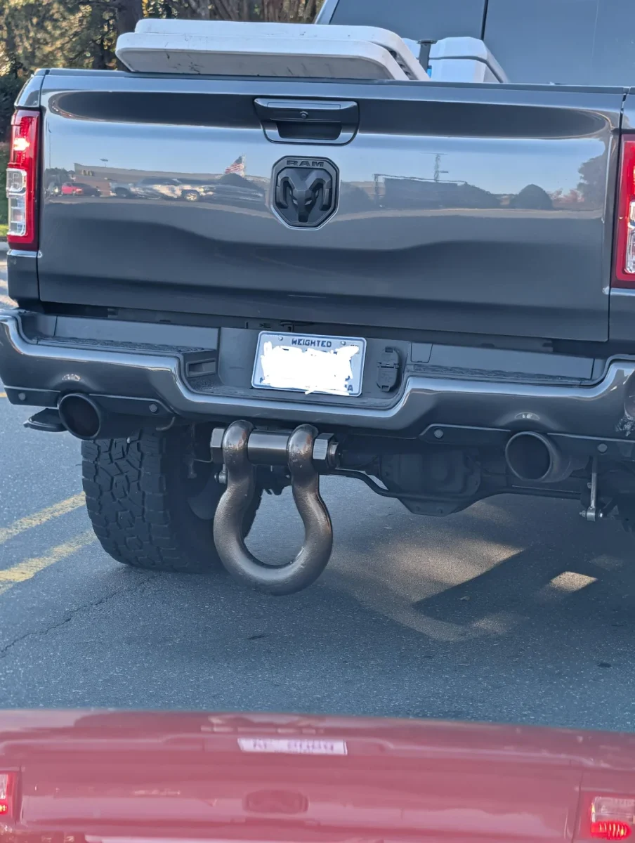 Šedé RAM auto s unikátnym zadným nárazníkom na ceste, veľký kovový hák pripevnený vzadu.