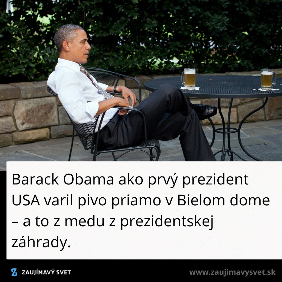 Muž v bielom košeli sedí pri stole s pivom na záhrade.