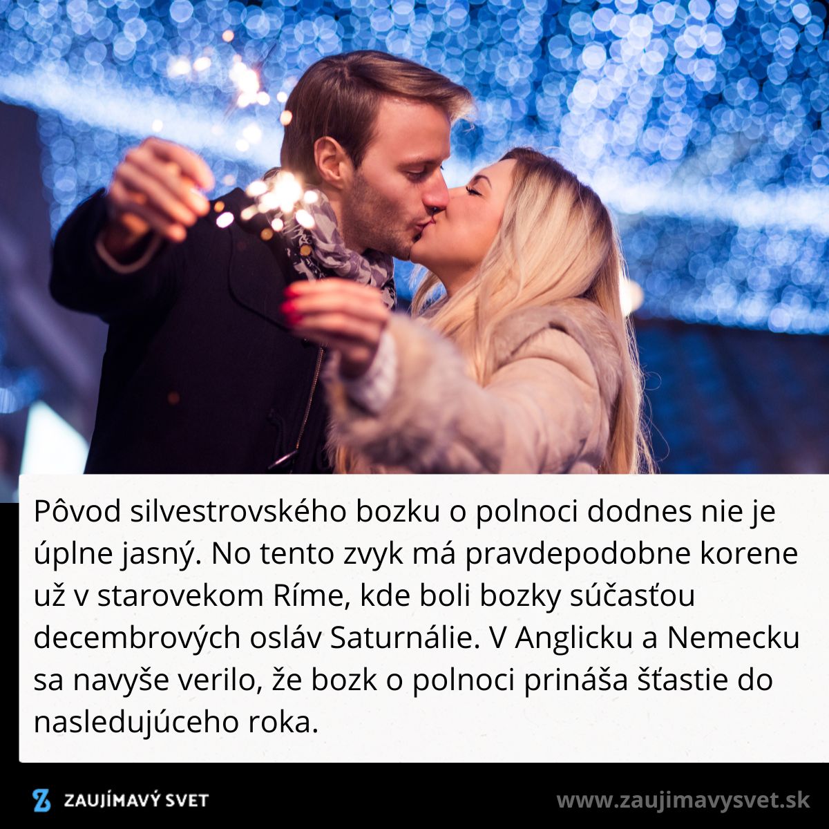 Pár si dáva novoročný bozk pri oslavách pod nočnou oblohou, obklopení svietiacimi prskavkami.