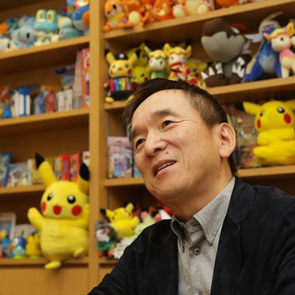 Osoba sediaca pred policou plnou Pokémon figúrok v kancelárii.