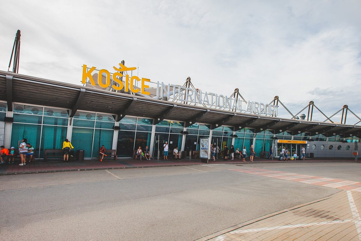 Exteriér medzinárodného letiska Košice s cestujúcimi čakajúcimi pred vstupnou halou.