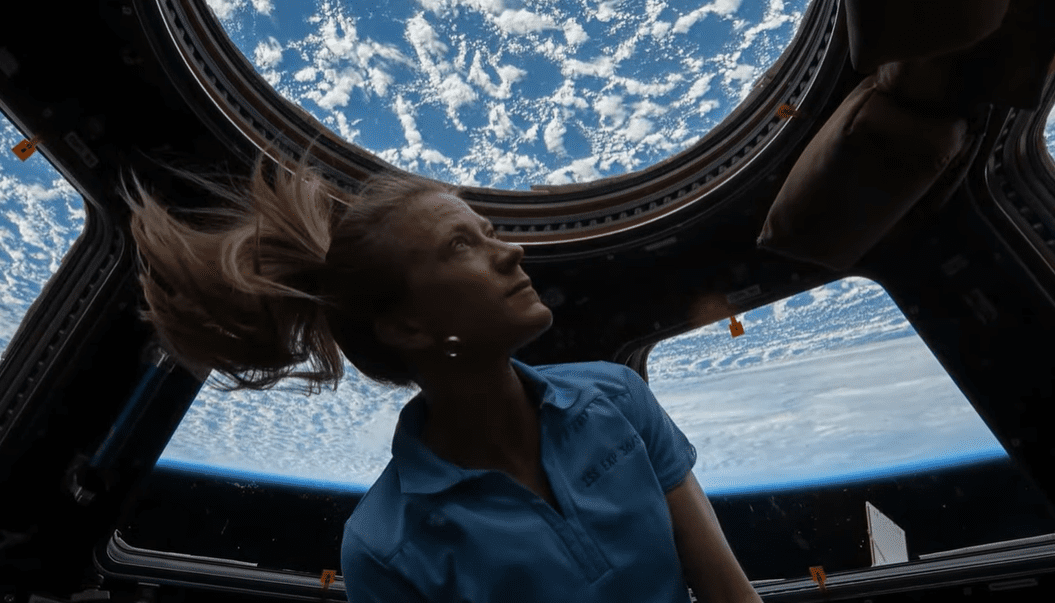 Astronautka pozoruje Zem z kupoly Medzinárodnej vesmírnej stanice.