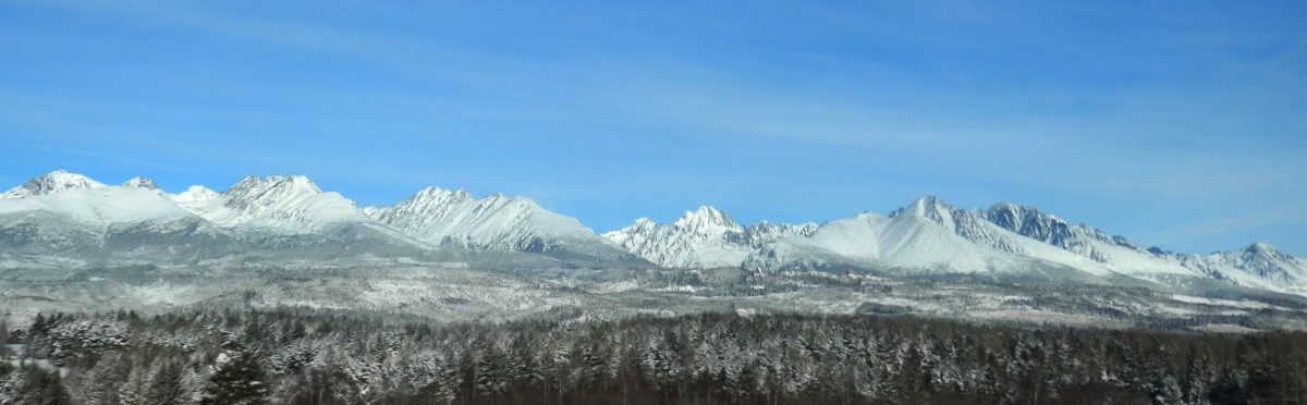 Zasnežené Tatry pod modrou oblohou ponúkajú nádherný pohľad na slovenskú horskú krajinu.