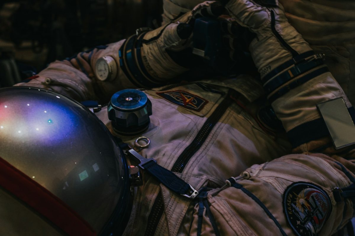 Astronaut v skafandri s dôrazom na prilbu odrážajúcu svetlo, pripravený na vesmírnu misiu.