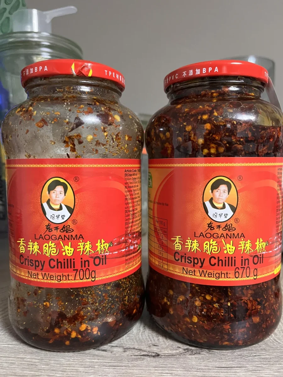Dva poháre Laoganma chilli v oleji s červenými etiketami a nápisom Crispy Chilli in Oil.