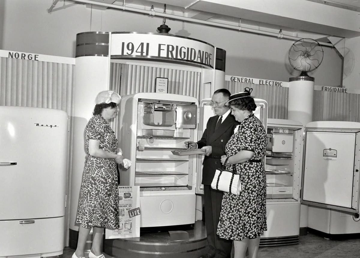 Predajca predstavuje model chladničky Frigidaire z roku 1941 dvom ženám na výstave domácich spotrebičov.