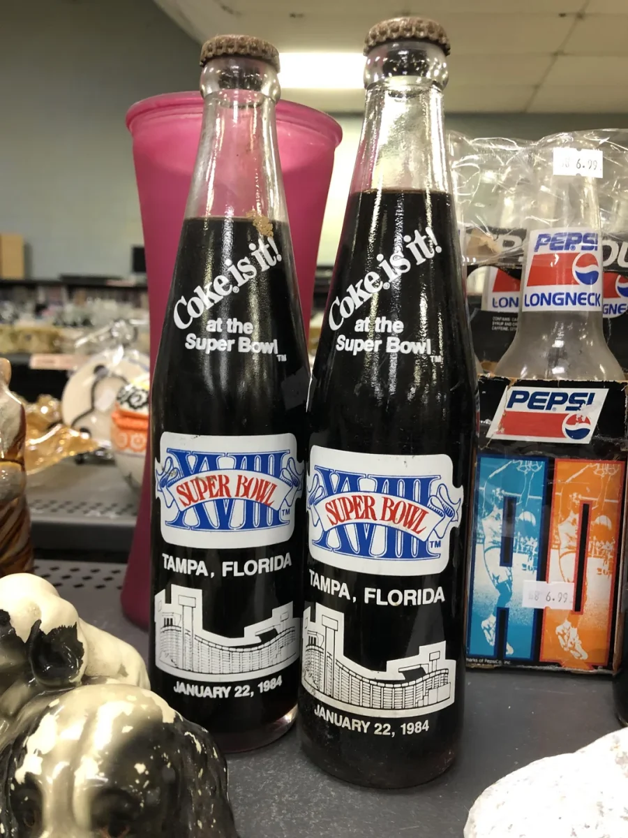 Dve fľaše Coca-Cola s logom Super Bowl XVIII, Tampa, Florida, z roku 1984, vystavené vedľa balenia Pepsi.