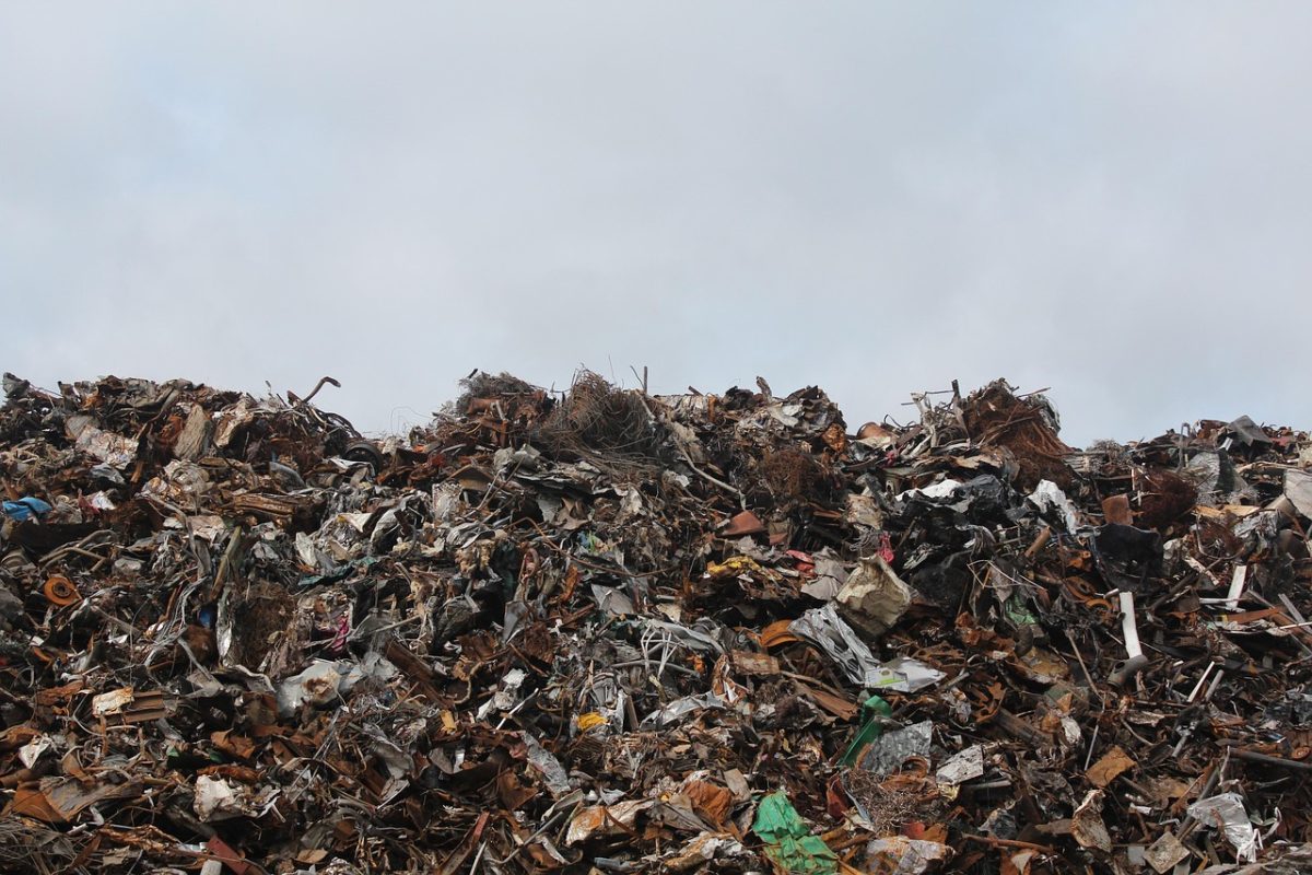 Hromada odpadu na skládke pod zamračenou oblohou, environmentálna výzva na recykláciu a udržateľnosť.