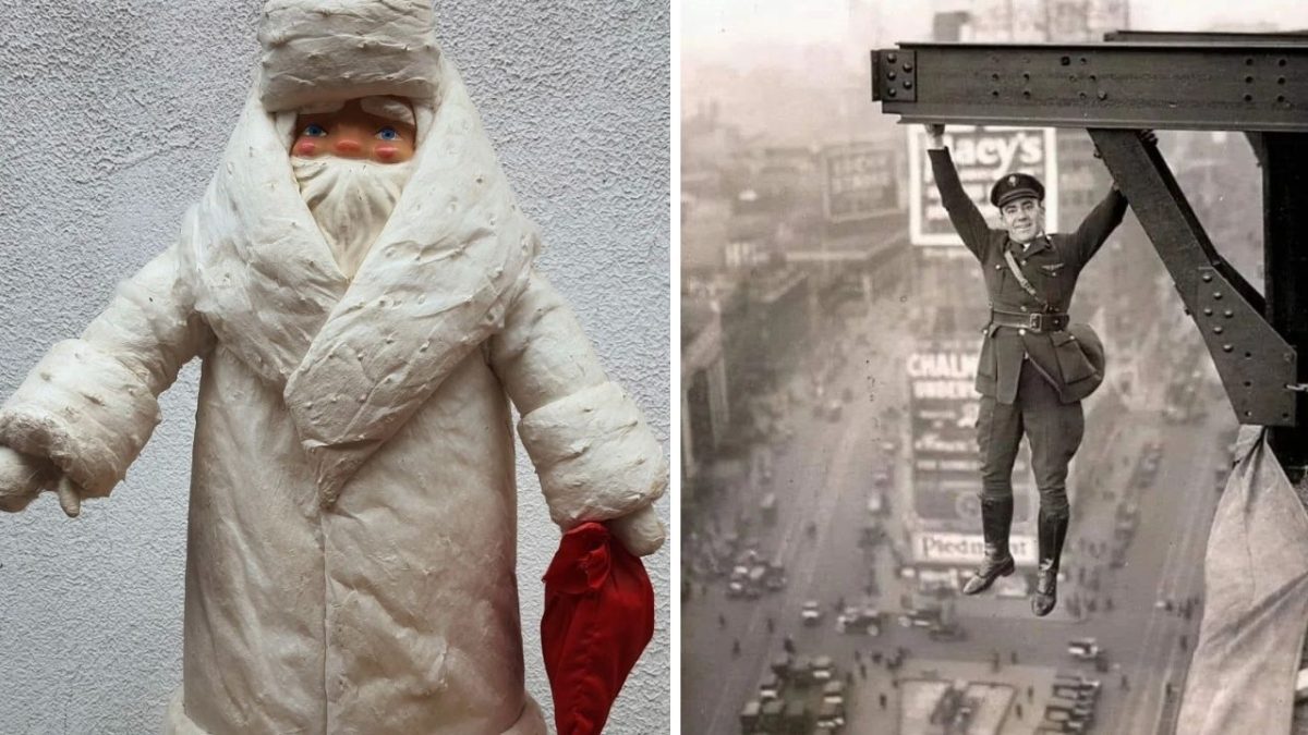 Bábka v bielom oblečení vedľa historickej fotografie muža visiaceho z konštrukcie nad mestskou ulicou.