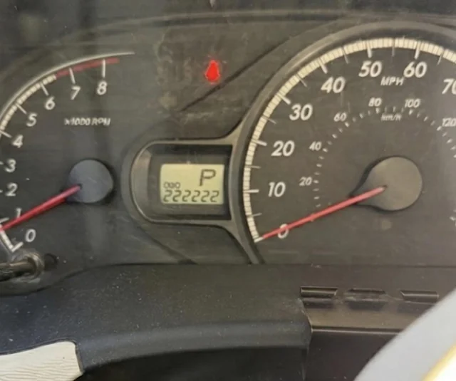 Tachometer s stavu počítadla 222,222 míľ, ukazuje vozidlo v parkovacom režime.