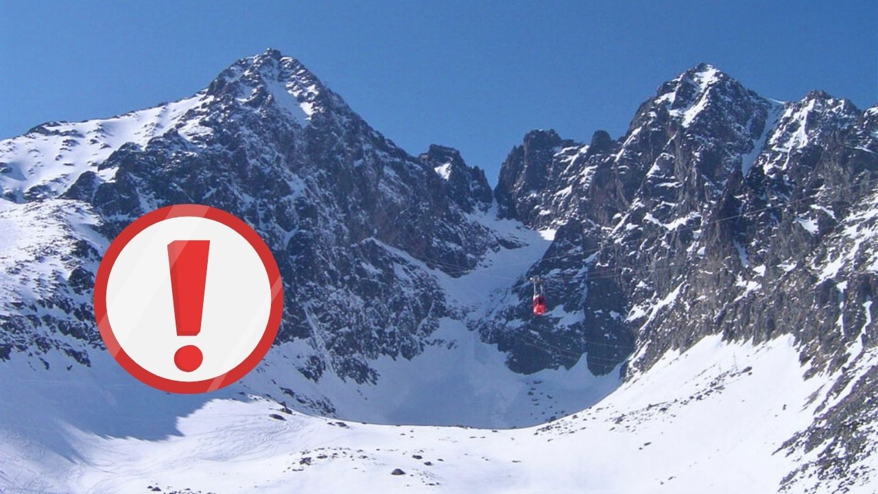 Výstražná značka v zasnežených Tatrách, varovanie pre turistov v horách.