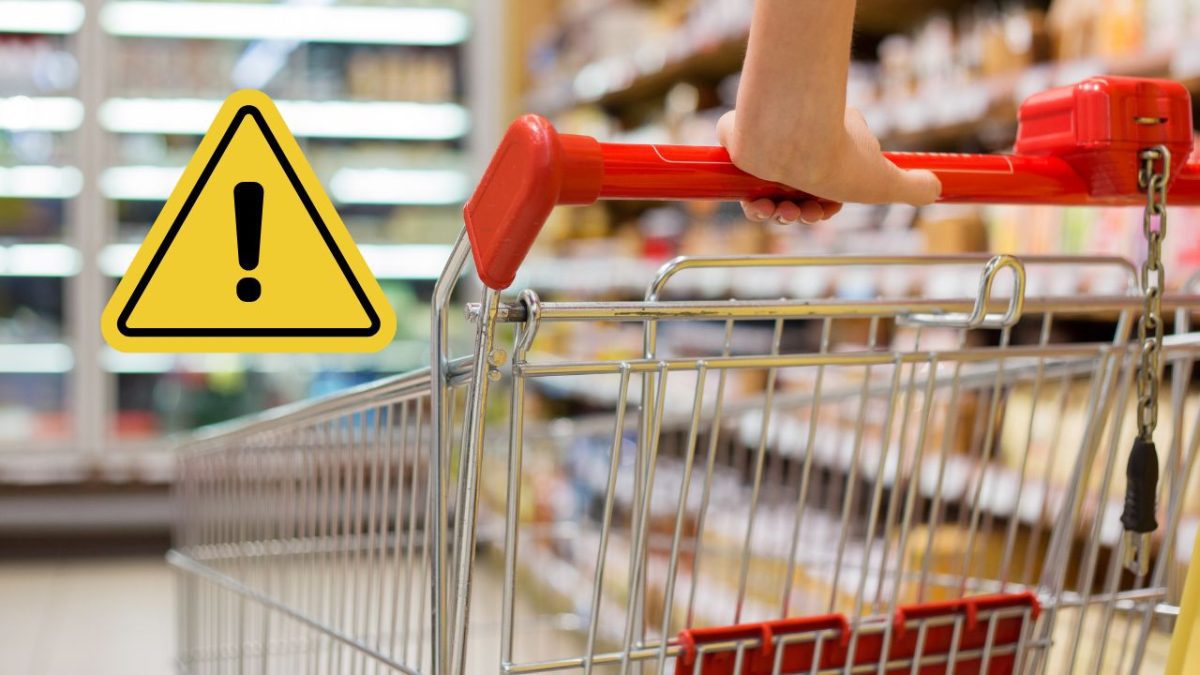 Nákupný vozík v supermarkete s varovným symbolom upozorňujúcim na opatrnosť pri nakupovaní.