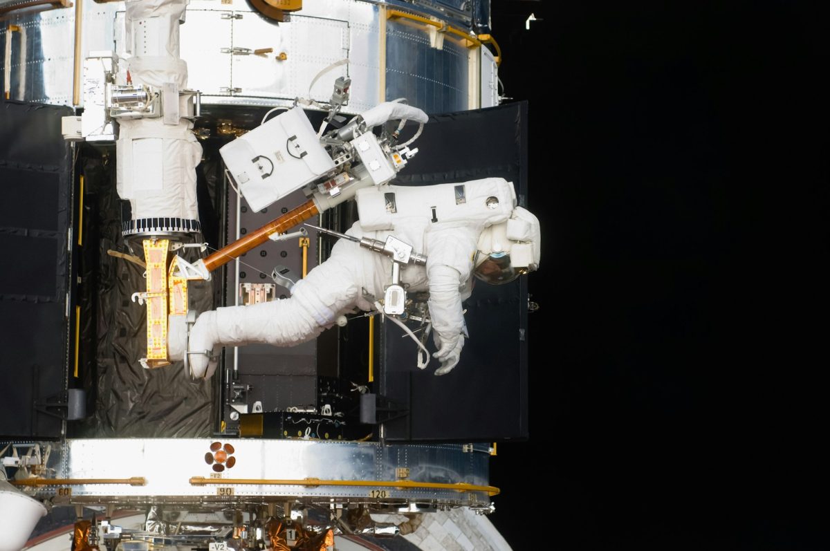 Astronaut pracuje na oprave vesmírneho teleskopu vo vesmíre.