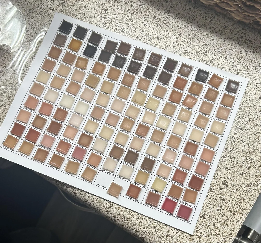 Paleta vzoriek béžových a hnedých odtieňov na kamennej doske na testovanie farieb dlaždíc.