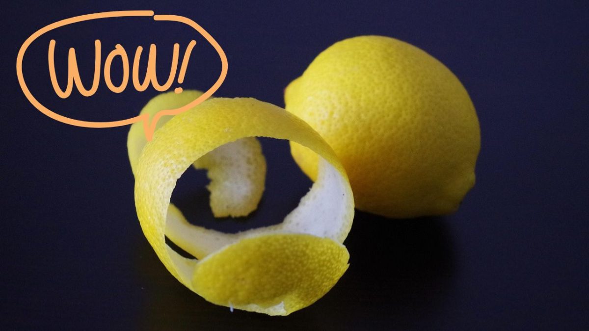 Olúpaný citrón s nápisom Wow! na tmavom pozadí, zdôrazňujúci sviežosť a citrusový šarm.