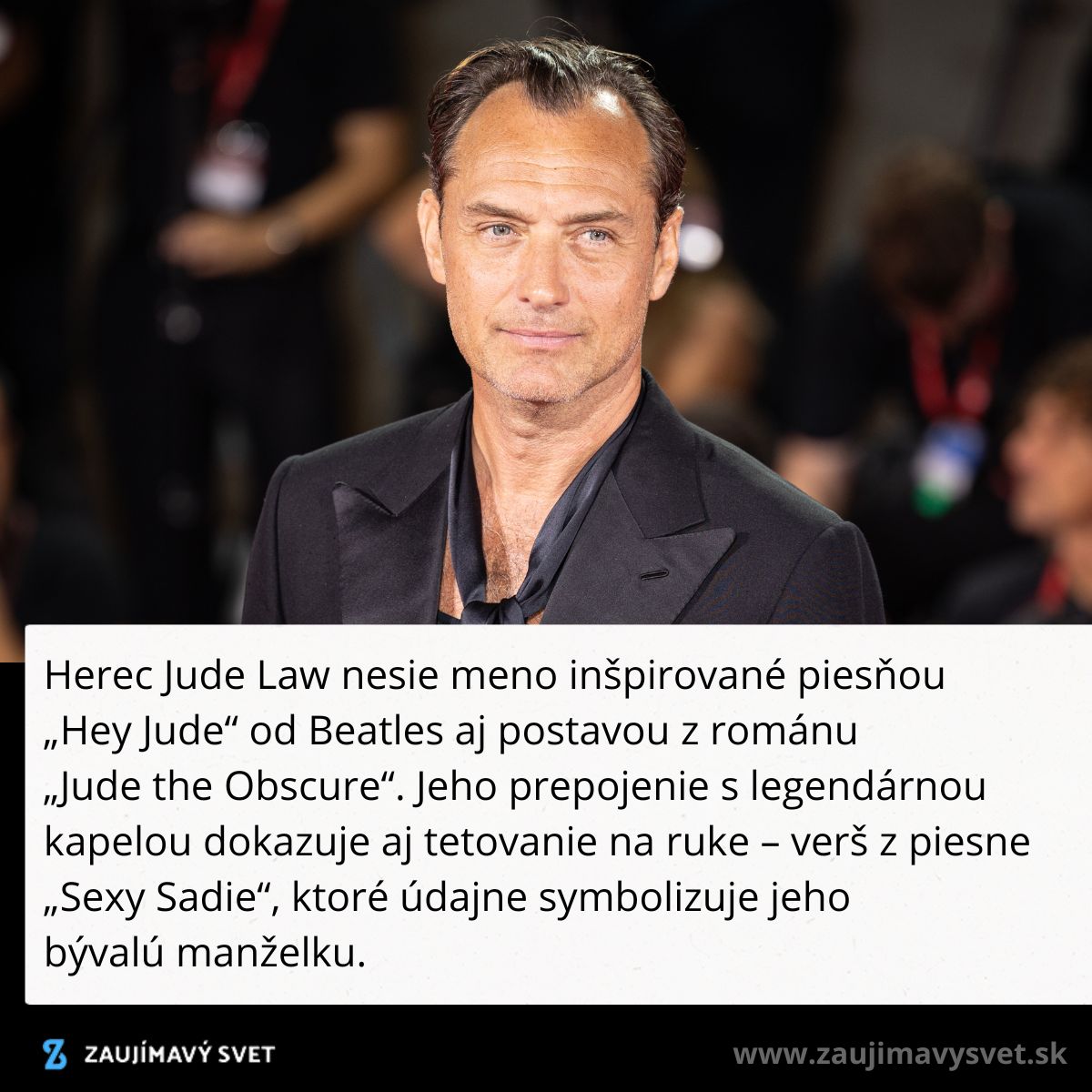 Neznámy muž v obleku na červenom koberci s divákmi v pozadí.