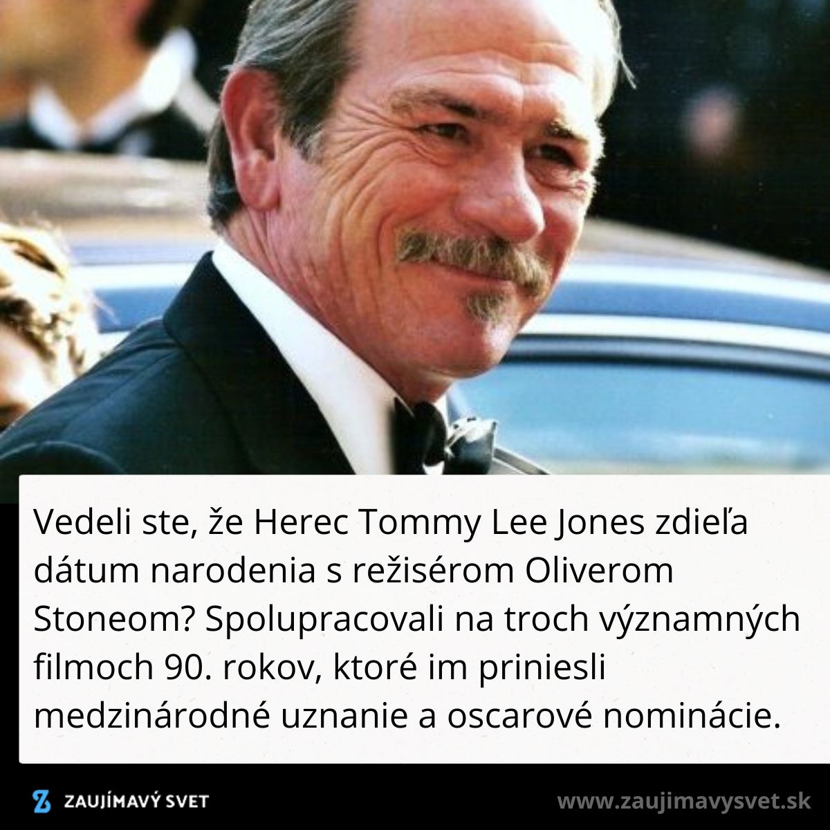 Herec na červenom koberci so širokým úsmevom, oblečený vo formálnom obleku.