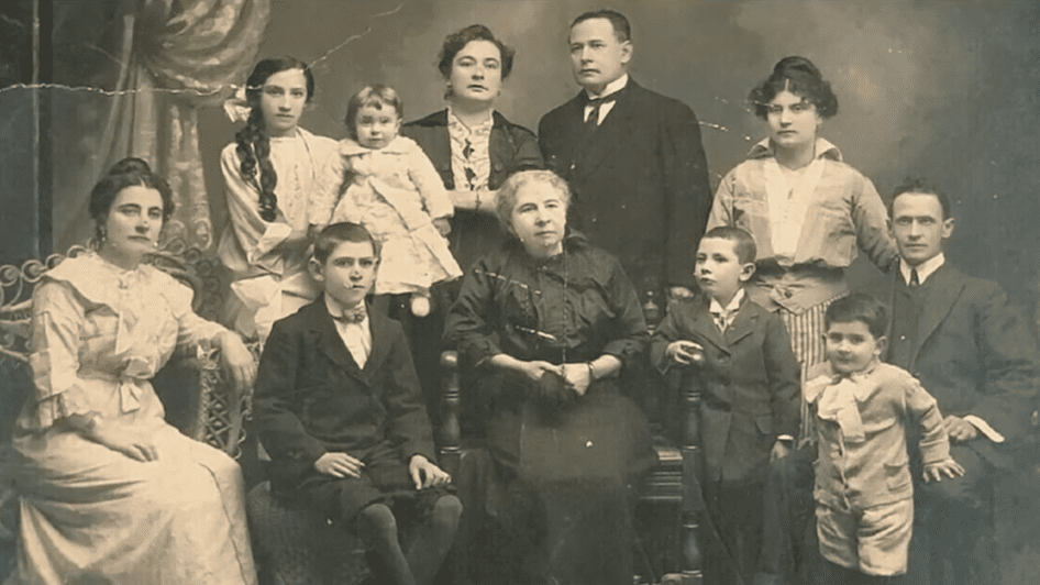 Historická rodinná fotografia, viacgeneračná skupina v dobových šatách, čiernobiele prevedenie.