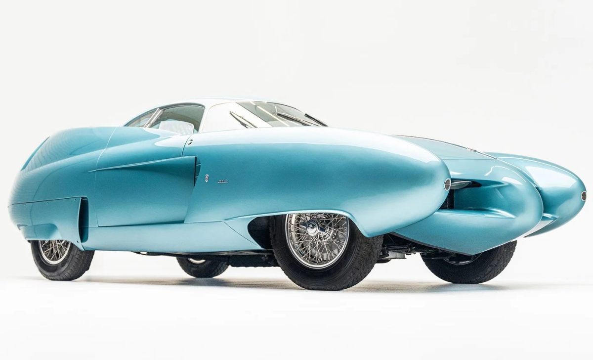 Retro futuristické auto v modrej farbe s unikátnym aerodynamickým dizajnom parkované na bielom pozadí.
