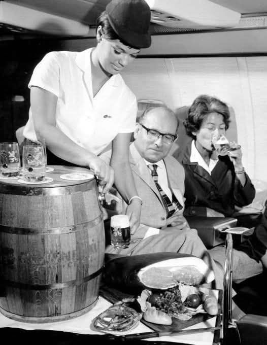 Letušky servírujú pivo a občerstvenie cestujúcim v luxusnej časti lietadla, 60. roky.