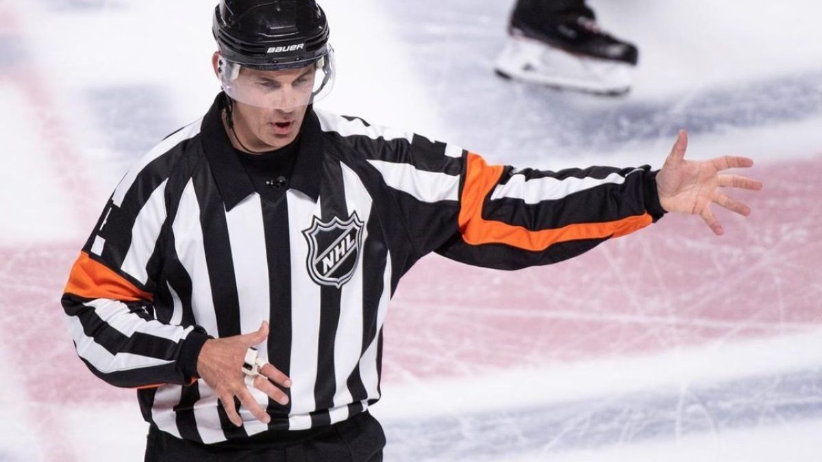 Hokejový rozhodca gesto predvádza na ľadovej ploche počas zápasu NHL.