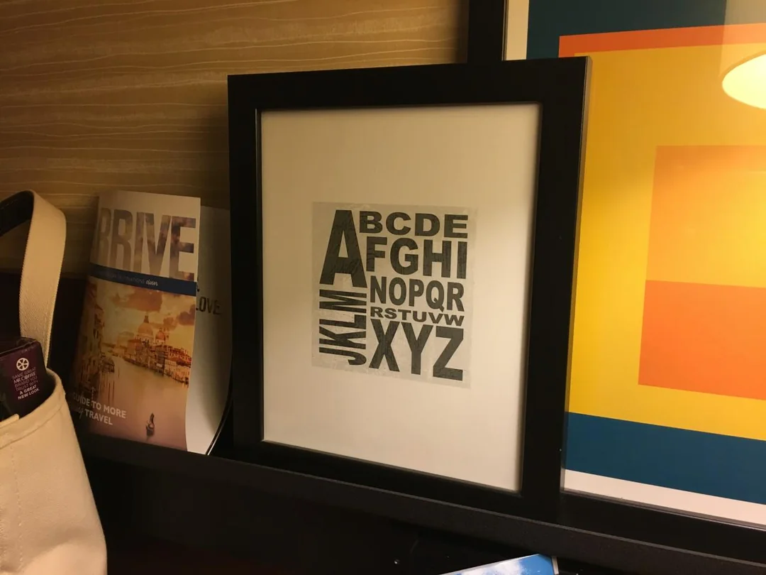 Rám s abecedou na polici pri knihách v modernom interiéri.