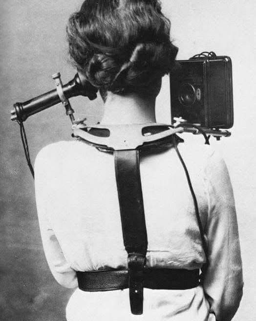 Žena s historickým fotografickým zariadením na tele, unikátne zachytávanie momentov.