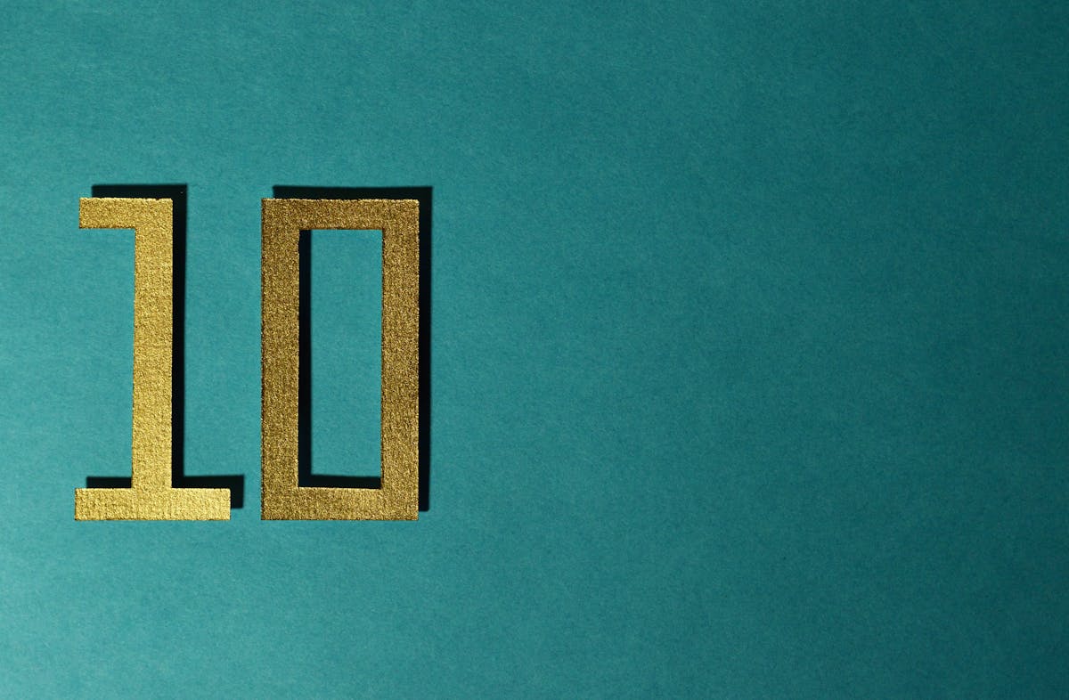 Stylish gold number ten on a textured teal background for design concepts.